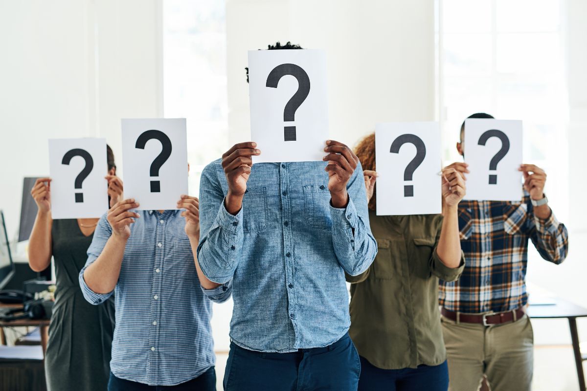 Medicare beneficiaries holding up question mark signs, asking questions about Medicare Part D