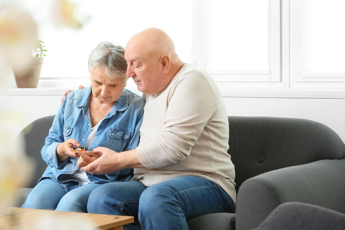 Husband helping his wife with her diabetic testing