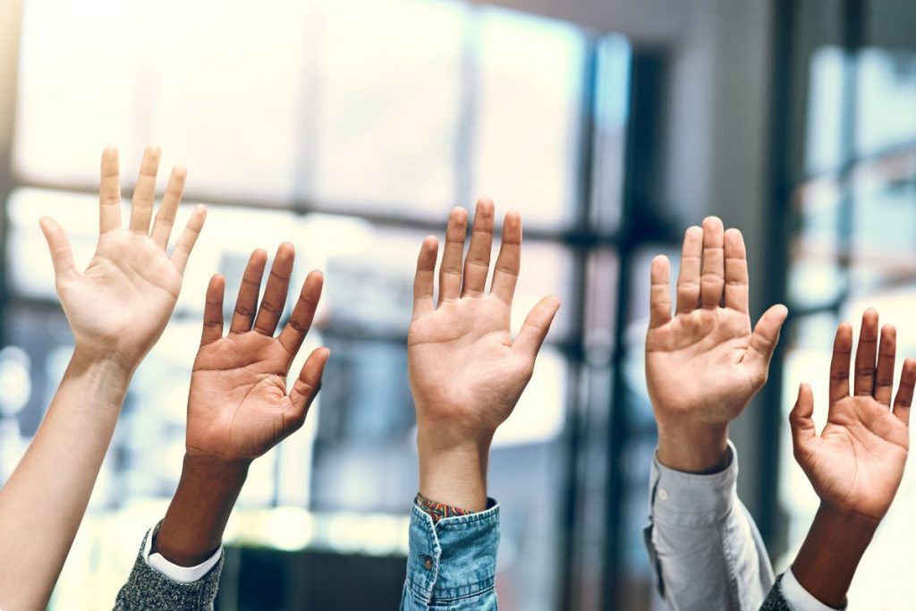 Hands raised with questions about having two insurance plans with Medicare